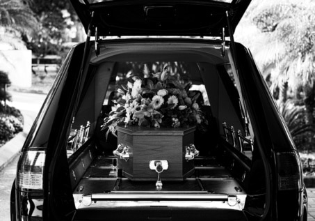 flowers and casket in back of vehicle